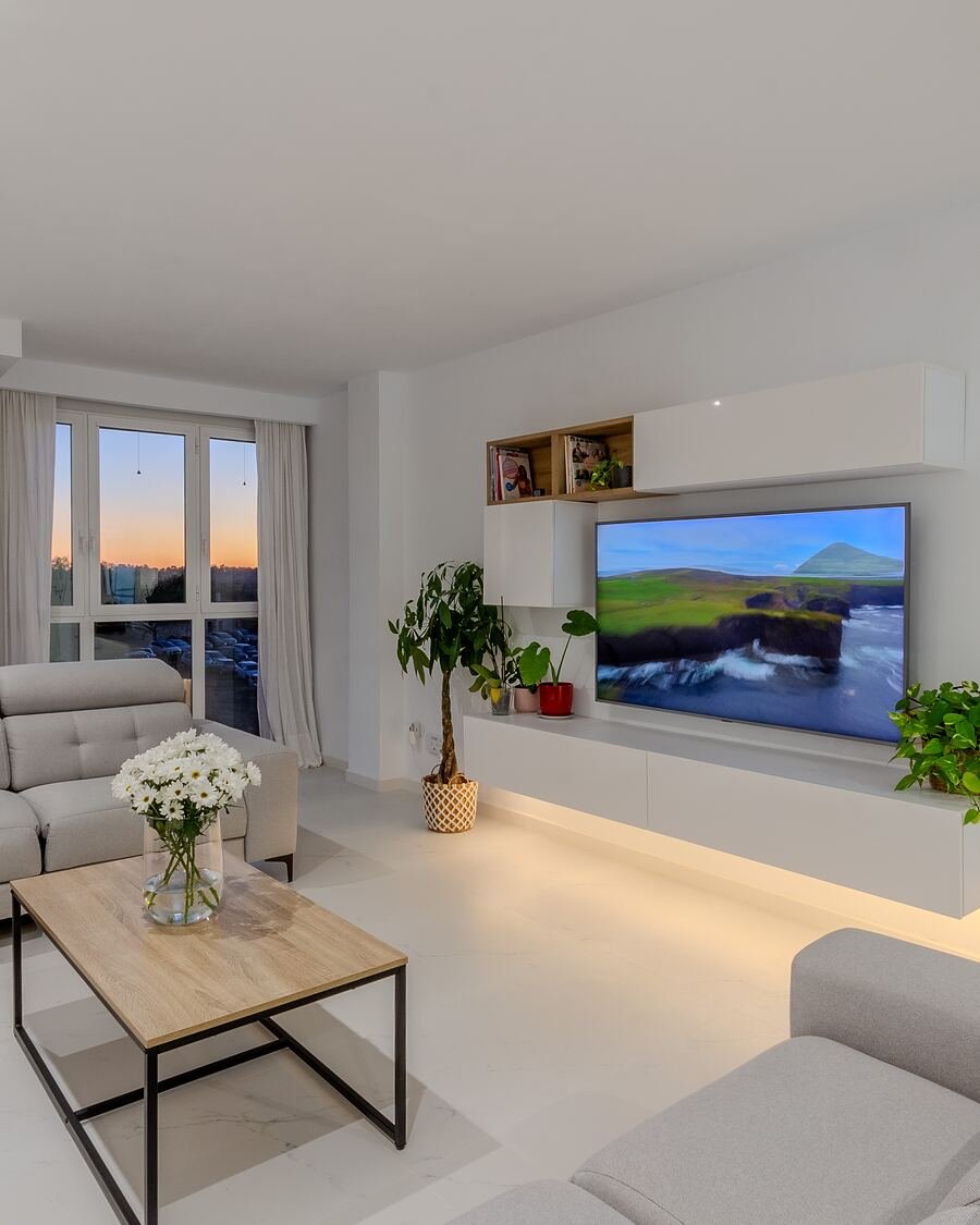 Salón de un apartamento de alquiler vacacional en la Costa Blanca, con el atardecer entrando por el ventanal