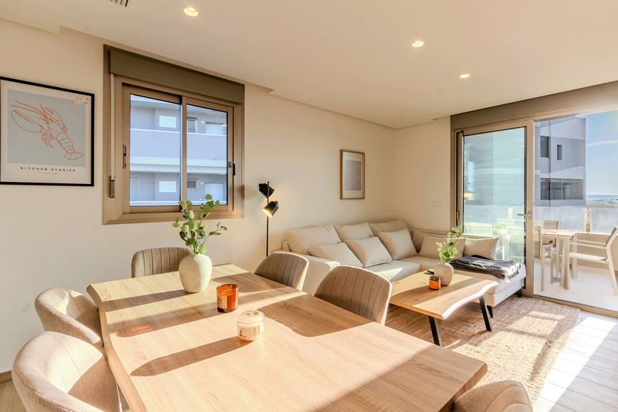 Ático Sunset Beach en Santa Pola: salón en tonos beige y verde salvia abierto a la terraza