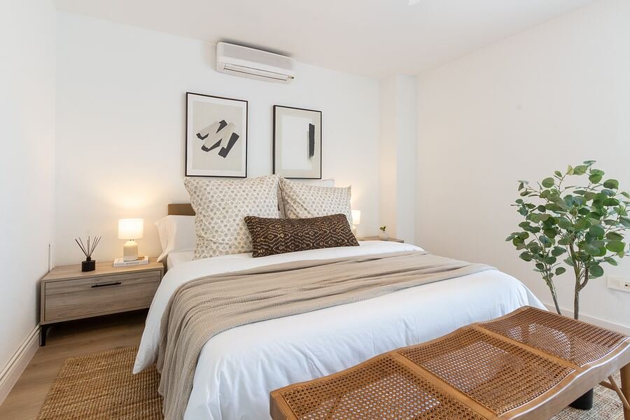 Villa Don Pueblo en Gran Alacant: dormitorio principal en blanco y tonos tierra, con dos láminas abstractas sobre el cabecero